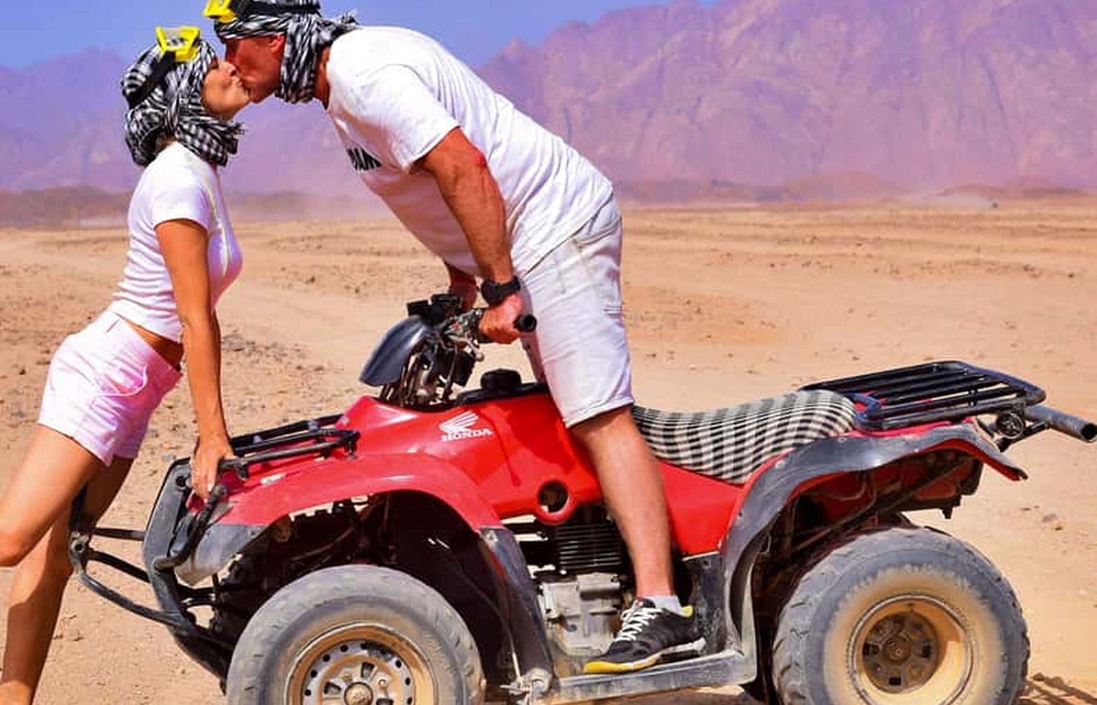 Family on a desert safari near Hurghada, a child riding as passenger with a parent on a quad